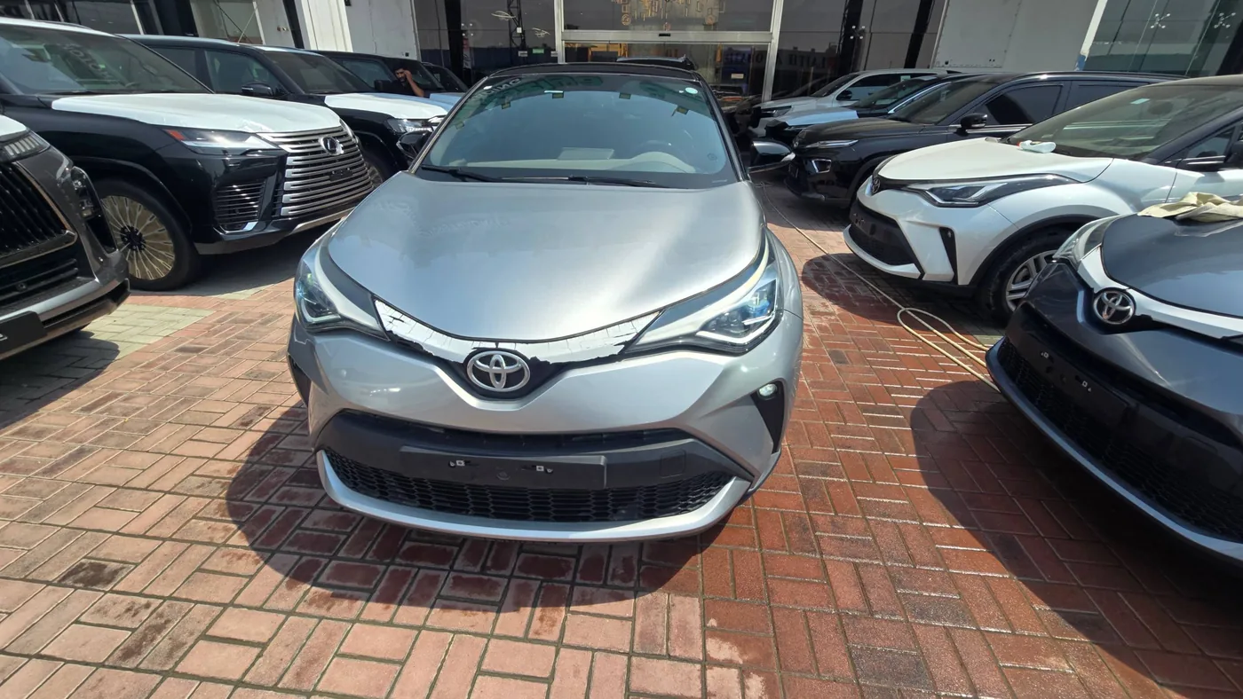 Серебристый Toyota C-HR 2022 на автомобильной площадке
